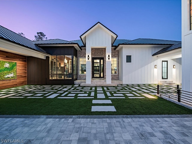 back house at dusk featuring a yard