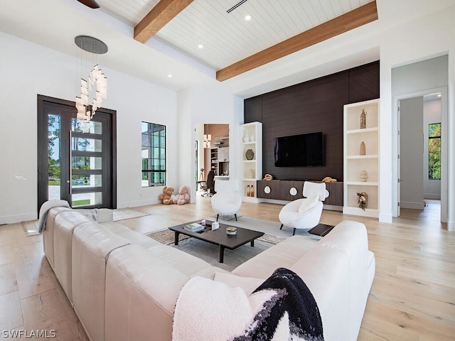 living room featuring a healthy amount of sunlight, light hardwood / wood-style floors, wood ceiling, and beamed ceiling