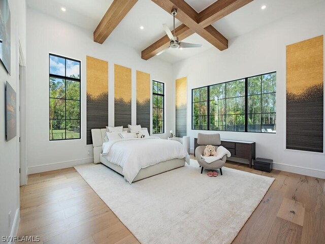 bedroom with beam ceiling, light hardwood / wood-style floors, and ceiling fan