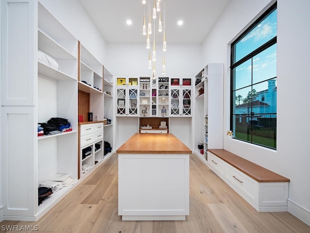 spacious closet featuring a notable chandelier and light wood-type flooring