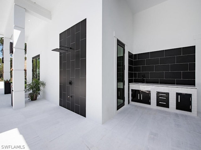 interior space with light tile floors and tile walls