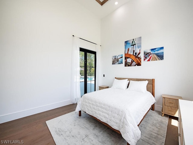 bedroom featuring high vaulted ceiling, access to outside, dark wood-type flooring, and french doors