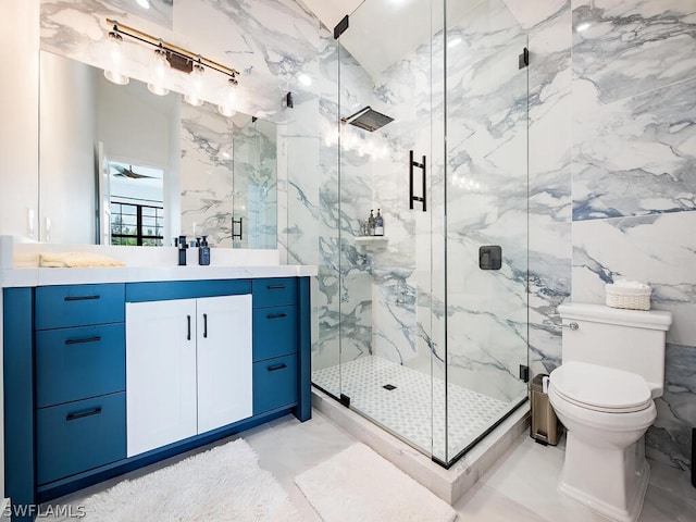 bathroom with toilet, a shower with door, tile floors, and vanity with extensive cabinet space