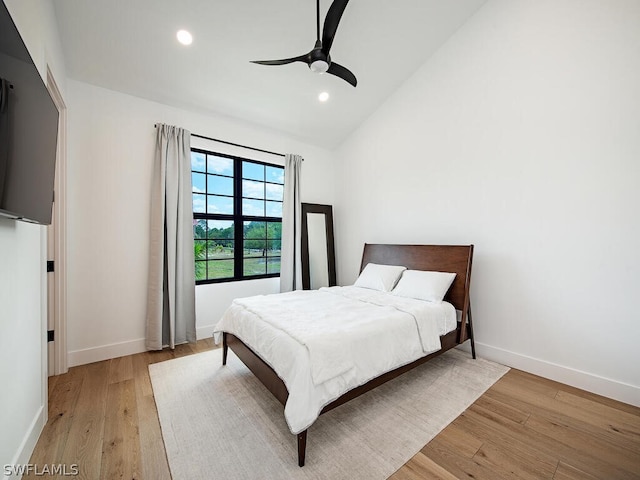 bedroom with lofted ceiling, light hardwood / wood-style floors, and ceiling fan