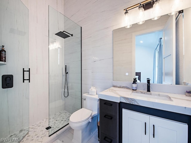 bathroom featuring toilet, vanity with extensive cabinet space, and a shower with door