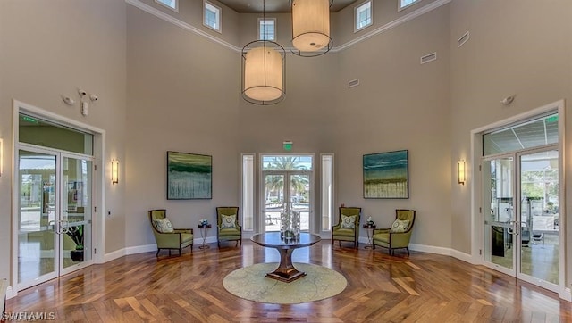 interior space featuring plenty of natural light, parquet floors, a high ceiling, and french doors