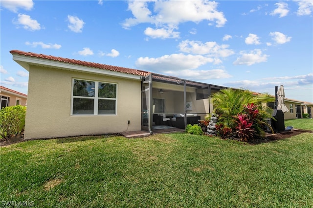 rear view of house with a lawn and a lanai