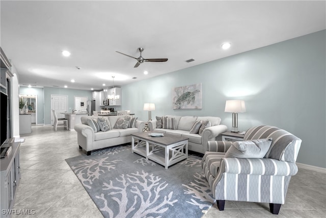 living room featuring ceiling fan with notable chandelier