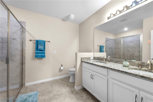 bathroom with vanity, a shower with shower door, and toilet