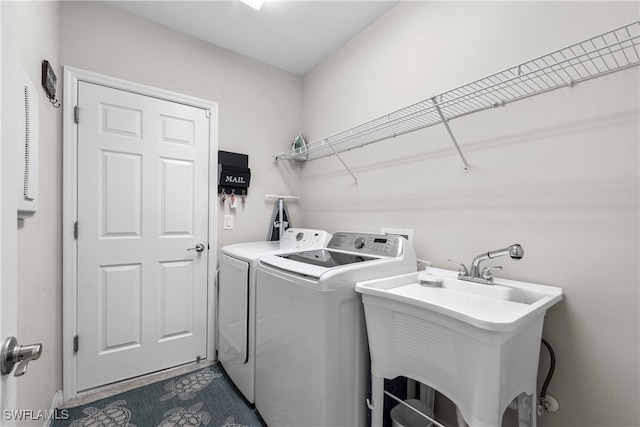 clothes washing area with independent washer and dryer and sink