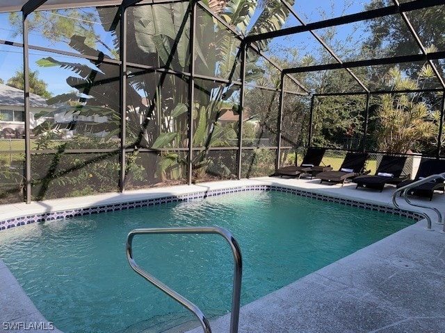 view of pool with a patio area and glass enclosure