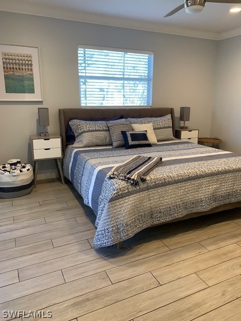 bedroom with ornamental molding, ceiling fan, and light wood-type flooring