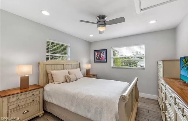 bedroom with multiple windows, ceiling fan, and light hardwood / wood-style flooring