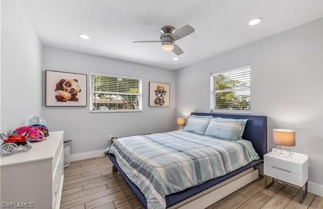 bedroom featuring multiple windows, light hardwood / wood-style floors, and ceiling fan