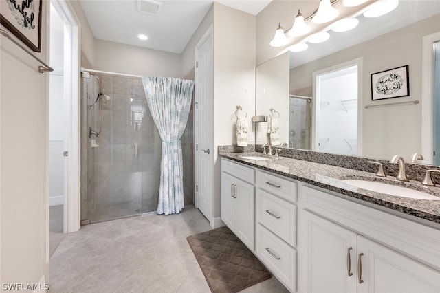 bathroom featuring a shower with shower curtain, tile flooring, large vanity, and dual sinks