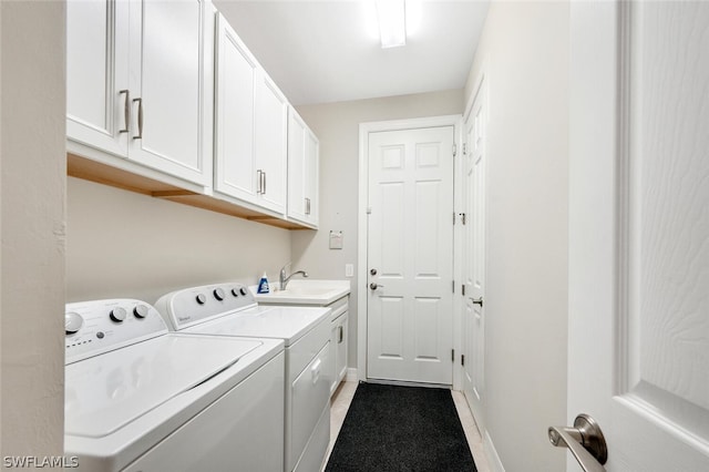 washroom featuring sink, cabinets, washing machine and clothes dryer, and light tile flooring