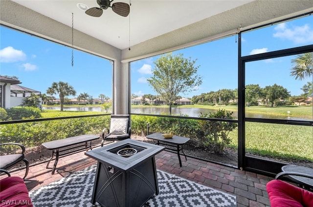 sunroom with a water view and ceiling fan