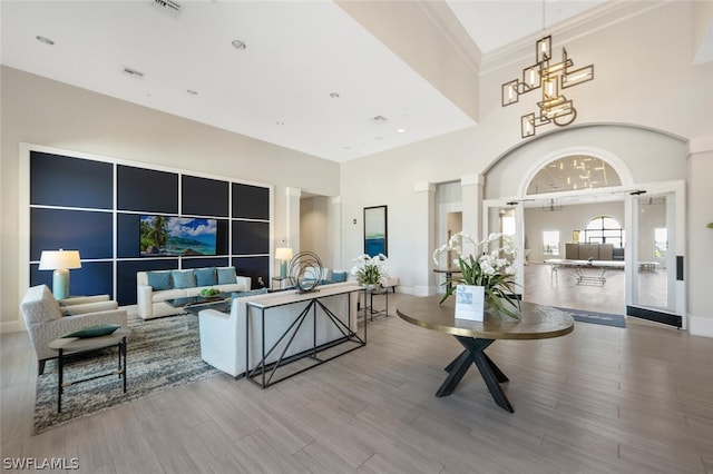 interior space with light hardwood / wood-style floors and a towering ceiling