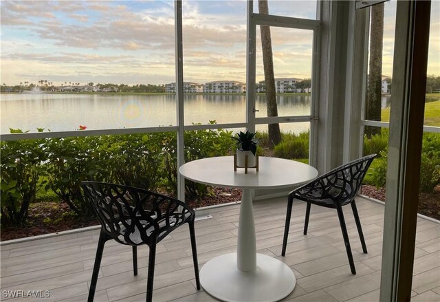 sunroom / solarium featuring a water view