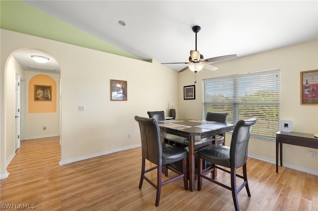 dining area with ceiling fan, light hardwood / wood-style flooring, and vaulted ceiling