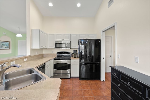 kitchen with decorative light fixtures, stainless steel appliances, high vaulted ceiling, sink, and tile floors