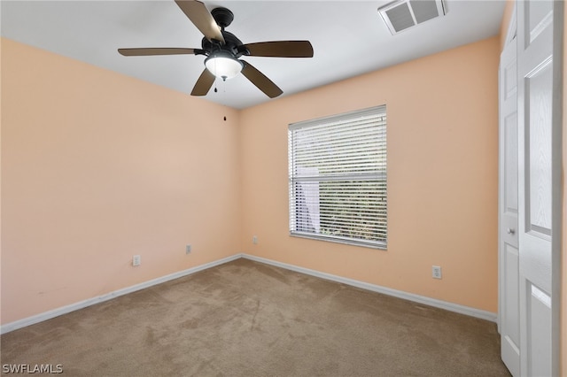 carpeted spare room with ceiling fan