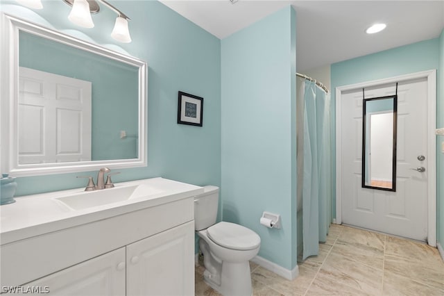 bathroom with tile flooring, toilet, and vanity