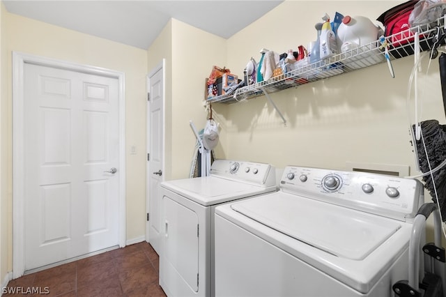 laundry area featuring dark tile flooring, separate washer and dryer, and hookup for a washing machine