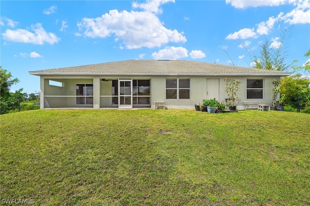 rear view of house with a sunroom and a yard