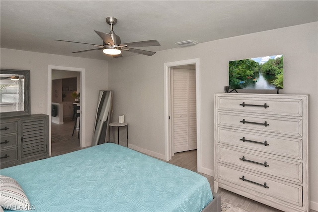 bedroom with ceiling fan, a closet, and light hardwood / wood-style flooring