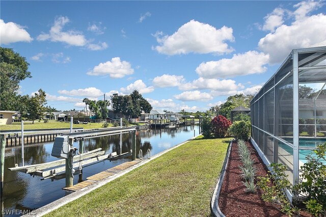 dock area featuring glass enclosure, a water view, and a lawn