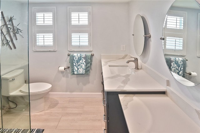 bathroom featuring large vanity, toilet, a wealth of natural light, and hardwood / wood-style flooring