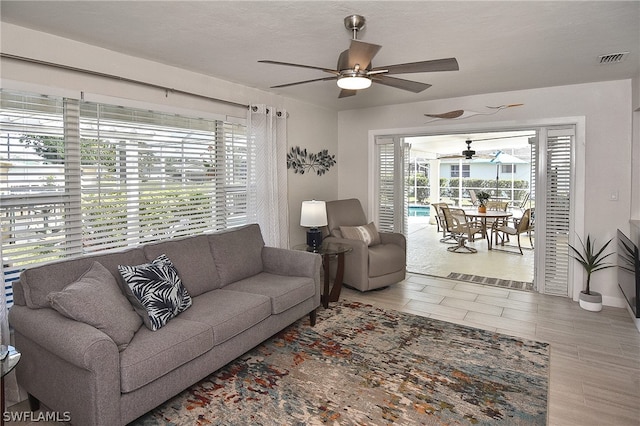 living room with light hardwood / wood-style floors and ceiling fan