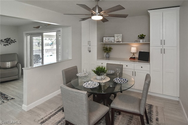 dining space with ceiling fan and light hardwood / wood-style flooring