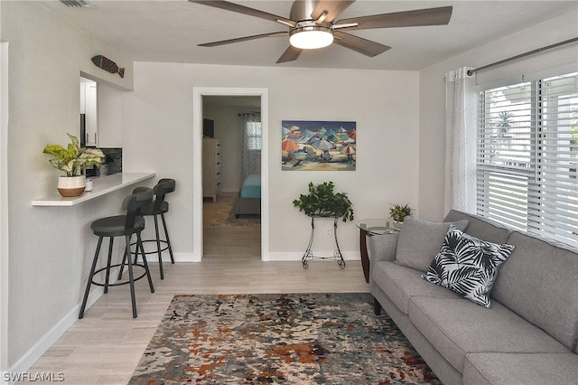 living room with ceiling fan and light wood-type flooring