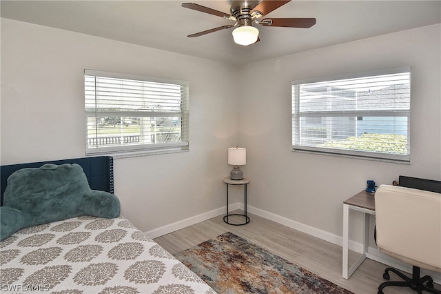 bedroom featuring multiple windows, light wood-type flooring, and ceiling fan