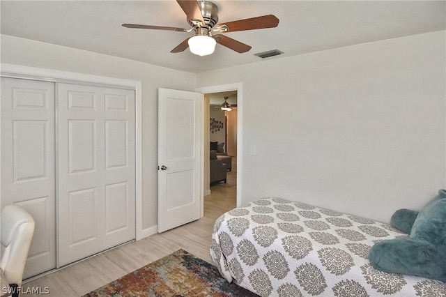 bedroom with a closet, ceiling fan, and light wood-type flooring