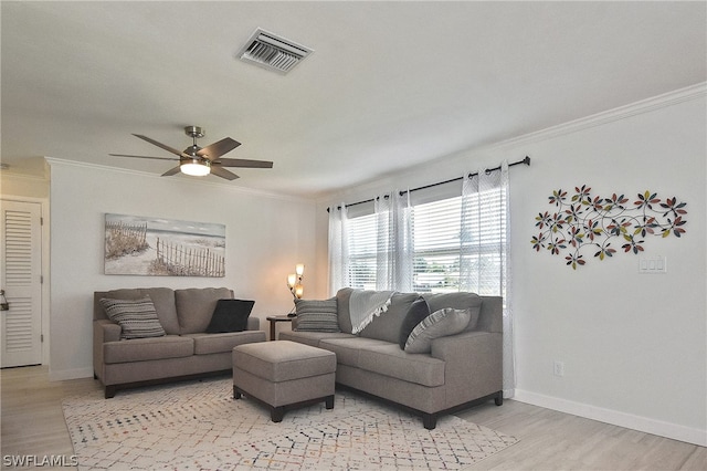 living room with ornamental molding, ceiling fan, and light wood-type flooring