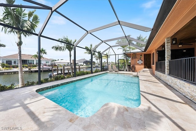 view of swimming pool featuring a dock, glass enclosure, a patio, and a water view