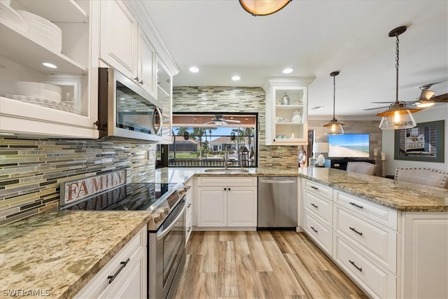 kitchen featuring ceiling fan, white cabinets, appliances with stainless steel finishes, light hardwood / wood-style flooring, and backsplash