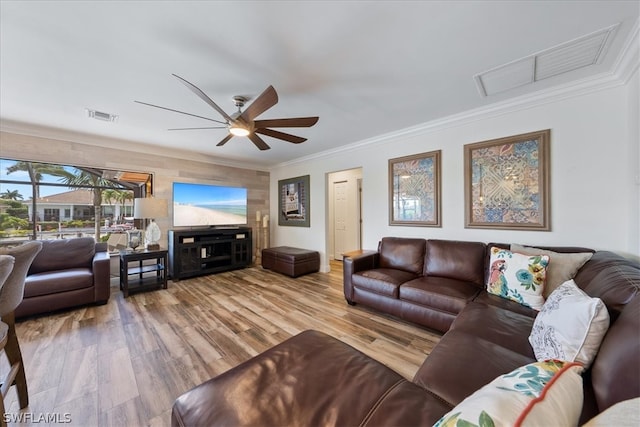 living room featuring light hardwood / wood-style floors, ornamental molding, and ceiling fan