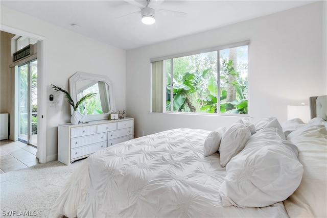 bedroom featuring light colored carpet, ceiling fan, access to outside, and multiple windows