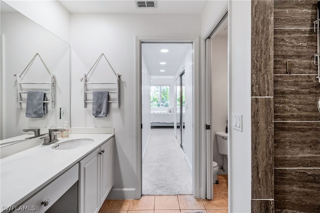 bathroom featuring tile flooring, toilet, and vanity