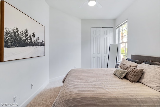 carpeted bedroom featuring ceiling fan and a closet