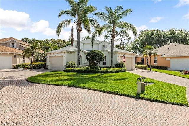 ranch-style house with decorative driveway, an attached garage, a front lawn, and stucco siding
