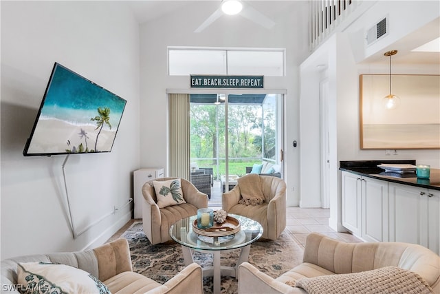 tiled living room with high vaulted ceiling and ceiling fan