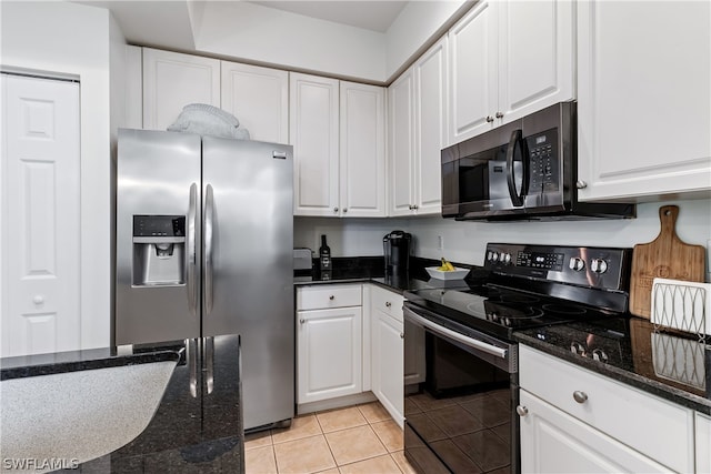 kitchen with appliances with stainless steel finishes, white cabinetry, and light tile floors