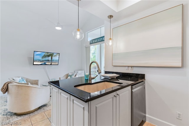 kitchen featuring light tile flooring, hanging light fixtures, dishwasher, sink, and white cabinetry