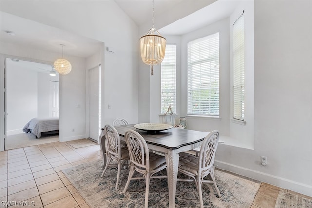 dining room featuring baseboards, a notable chandelier, light tile patterned floors, and vaulted ceiling