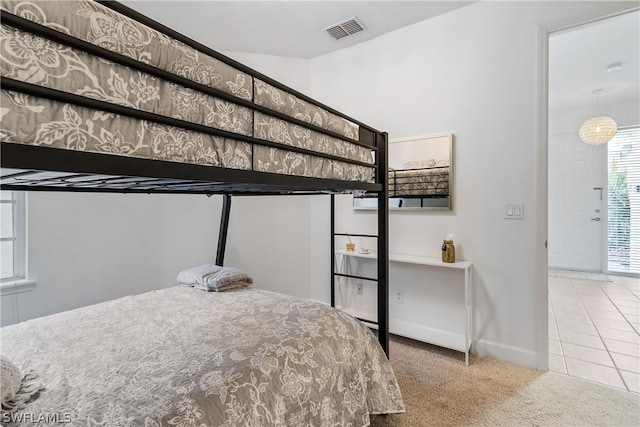 bedroom with an inviting chandelier and light tile floors